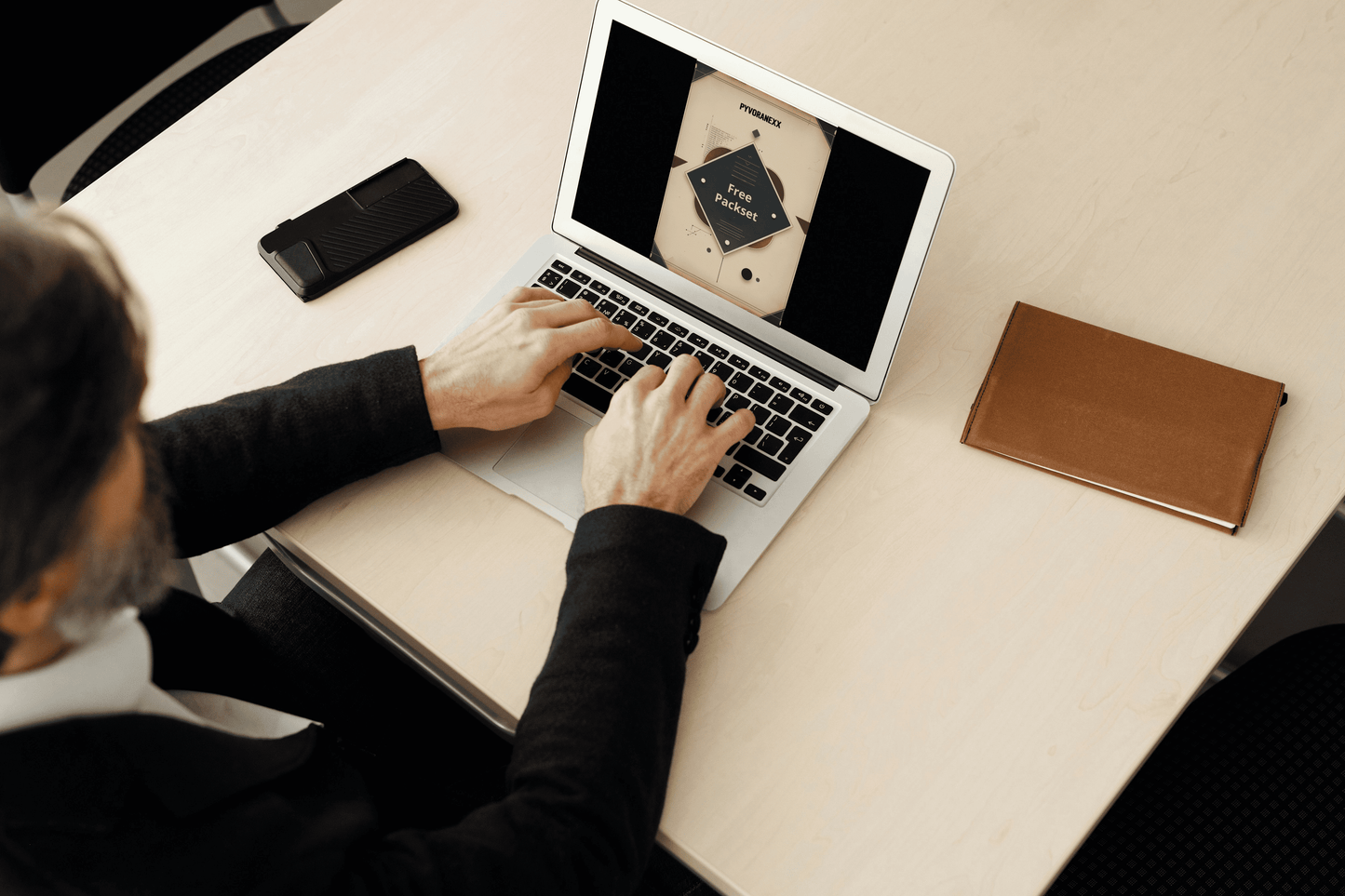 Person using a laptop with Python course on a desk with a phone and notebook nearby