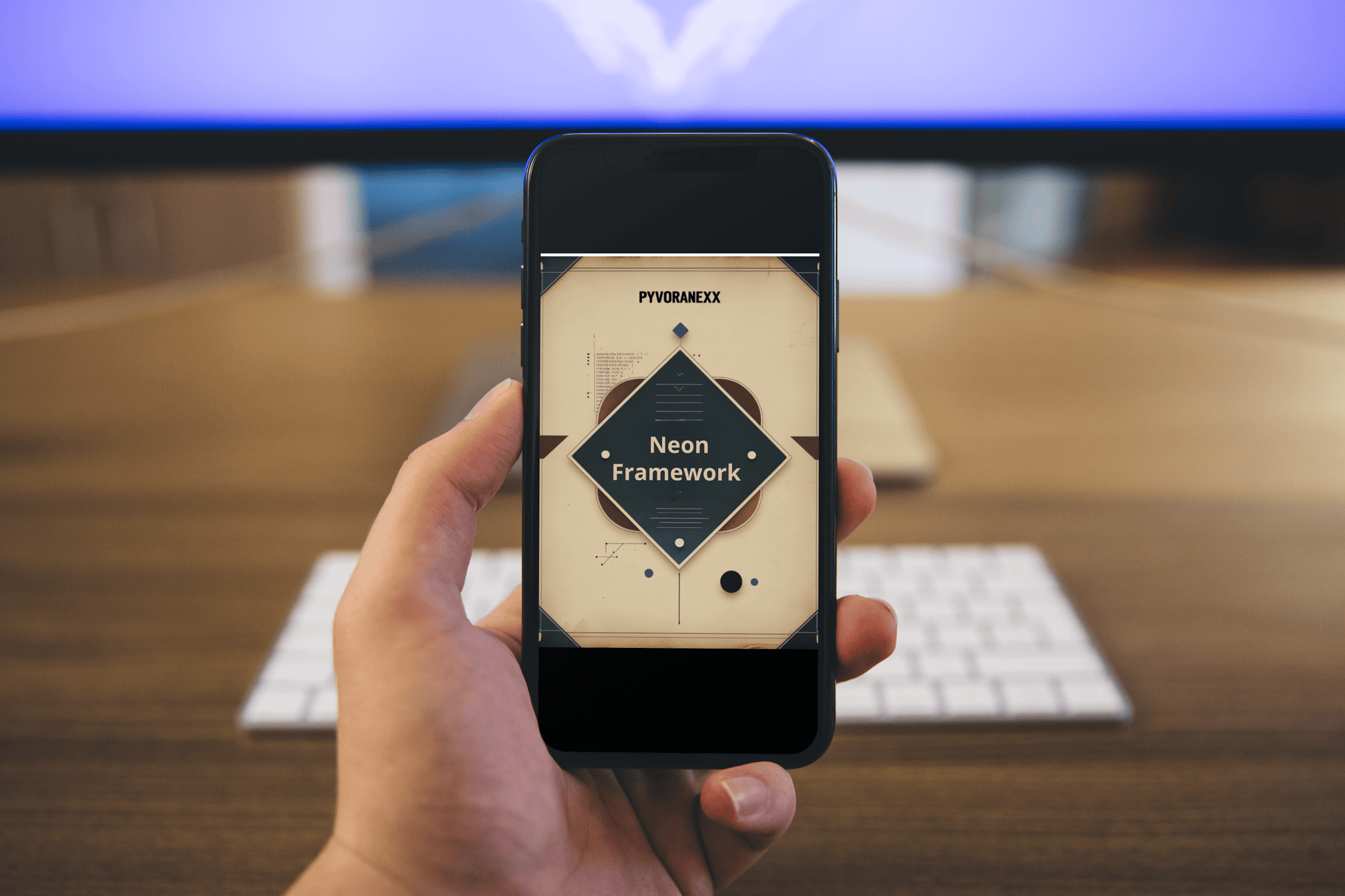 Hand holding a smartphone displaying a neon framework course on a blurred office desk background